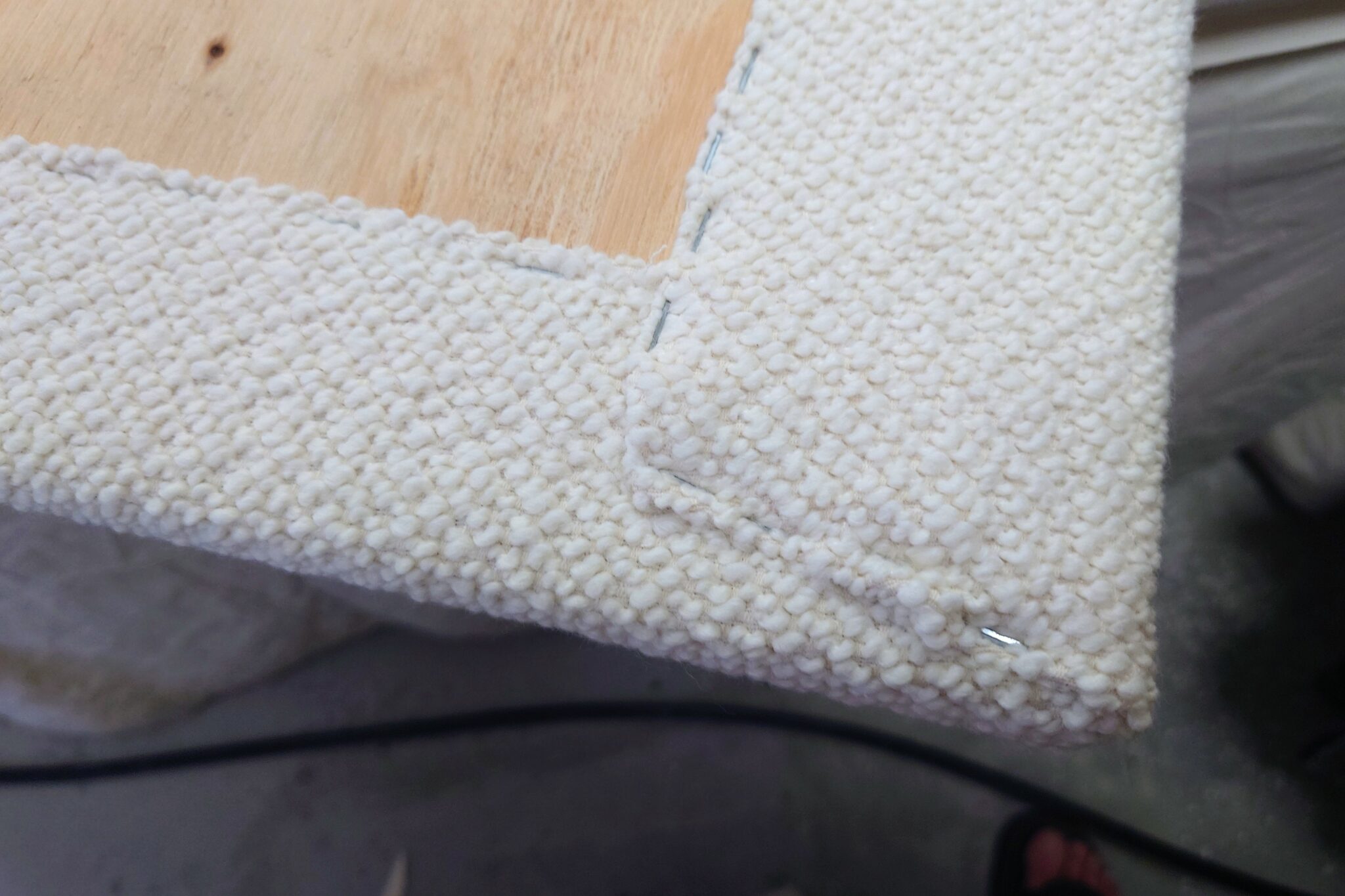 Upholstered panel headboard with clean, sharp corners, made in a French upholstery workshop