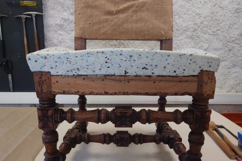 Foam padding shaped over profiles during the reupholstering of an antique chair